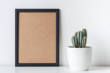 Modern Oda Dekorasyon. Kaktüs bitkisi beyaz çiçek tencerede. Mock-up siyah bir çerçeve ile.