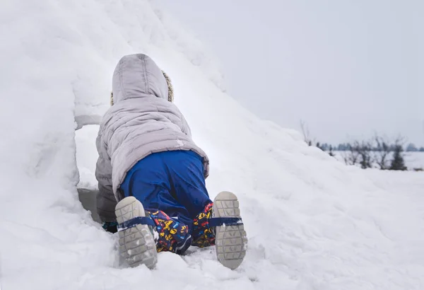 小孩爬进雪堡 在后院里建造 隐藏和寻找 冬季家庭娱乐活动 — 图库照片