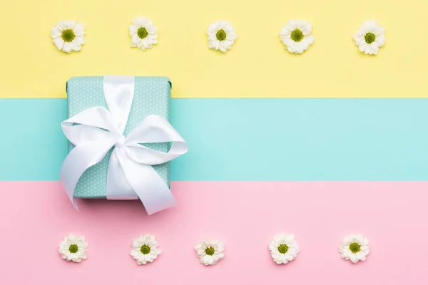 Happy Mother's Day, Women's Day, Valentine's Day or Birthday Pastel Candy Colours Background. Floral flat lay minimalism greeting card with a gift box.