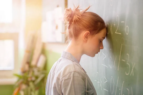 Genç kız matematik dersinde matematik formül tarafından boğulmuş. Basınç, eğitim, başarı kavramı.