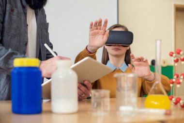Genç öğretmen öğrencilere kimya sınıfında sanal gerçeklik gözlükleri ve 3d tanıtımı kullanarak. Eğitim, Vr, ders, yeni teknolojiler ve öğretim yöntemleri kavramı. 