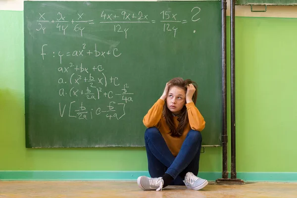 Genç kız matematik dersinde matematik formül tarafından boğulmuş. Basınç, eğitim, başarı kavramı.