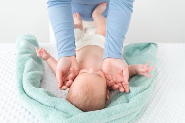 Bebek yüz masajı konsepti. Masöz ya da anne iki eliyle bebeğin yüzünü nazikçe okşuyor. Kesilmiş vuruşu kapat.