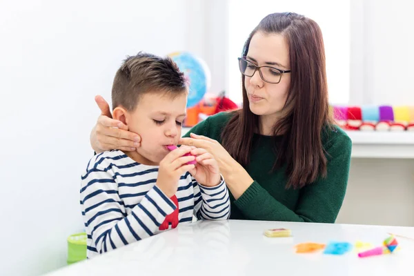 Children speech therapy concept. Preschooler practicing correct pronunciation with a female speech therapist.