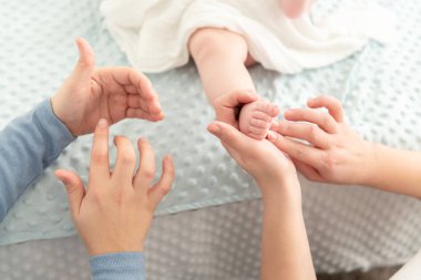 Bayan masaj terapisti genç anneye yeni doğmuş bebeğine nasıl masaj yapılacağını öğretiyor. Bebek masajı konsepti. Kesilmiş atış ellere yakın..