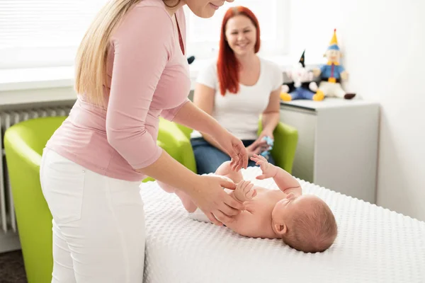Masajista Femenina Médico Examinando Bebé Recién Nacido Con Madre Mirando —  Fotos de Stock
