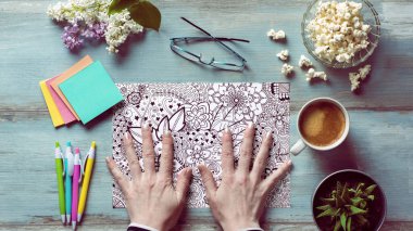 Yetişkin boyama kitabı, stres atma eğilimi. Sanat terapisi, akıl sağlığı, yaratıcılık ve farkındalık konsepti. Yetişkin boyama kitabı arkaplanını boyayan kadınların ellerine yakın çekim.