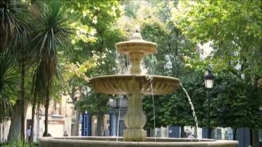 Granada, İspanya - 29 Eylül 2018: Yapraklı kareye su fışkırtan iki katlı fıskiye