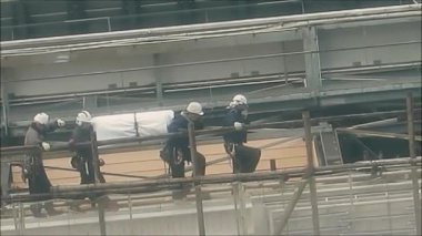 Tokyo, Japonya - 7 Aralık 2019: Bilinmeyen nesneleri çatıdan taşıyan bir grup inşaat işçisi