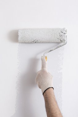 Bir duvar boya silindiri ile boyama ressam kolu yakın çekim
