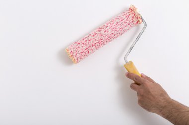 Bir duvar boya silindiri ile boyama ressam kolu yakın çekim