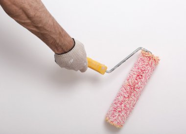 Bir duvar boya silindiri ile boyama ressam kolu yakın çekim