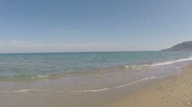 Kumlu sahilde yumuşak bir mavi deniz dalgası