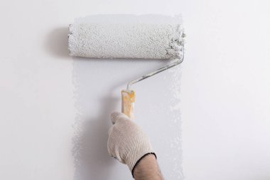Bir duvar boya silindiri ile boyama ressam kolu yakın çekim