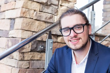 Tam takım gözlük takıyor kendine güvenen genç adam