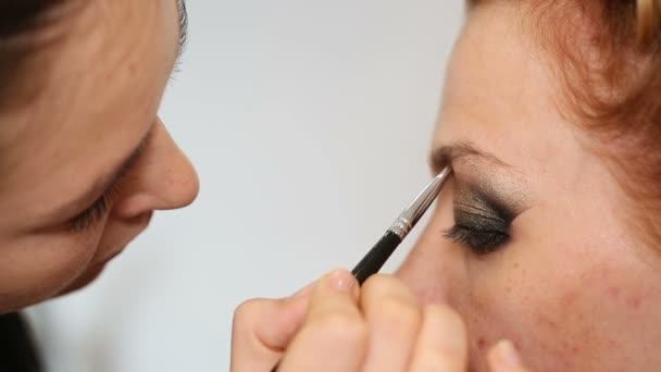 Professionell makeup artist sätta kosmetika på modell ansikte — Stockvideo