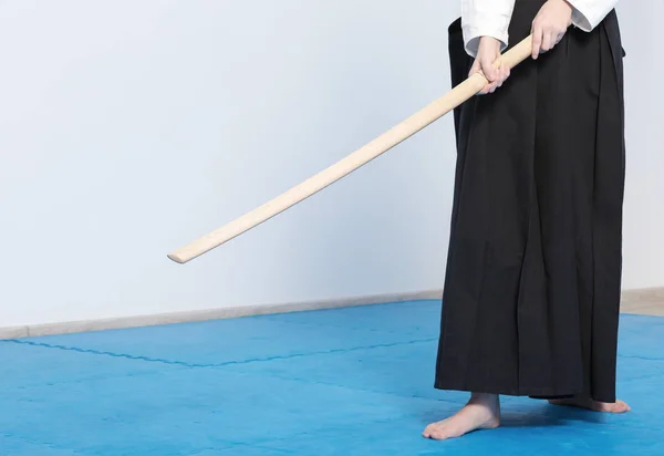 En flicka i svart hakama stående med trä svärd — Stockfoto