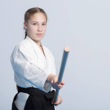 Bir kız siyah hakama ayakta poz tahta jo sopa ile mücadelede
