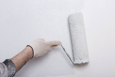 Bir duvar boya silindiri ile boyama ressam kolu yakın çekim