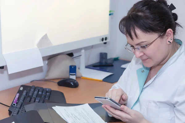 Médico de rayos X femenino navegando por Internet con su smartphome — Foto de Stock