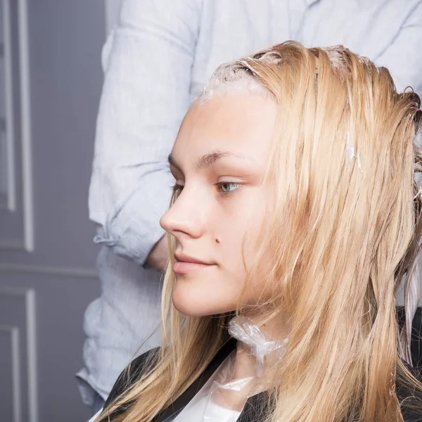 Ένα χαριτωμένο ξανθό κορίτσι χρωματίζοντας τα μαλλιά σε κομμωτήριο — Φωτογραφία Αρχείου