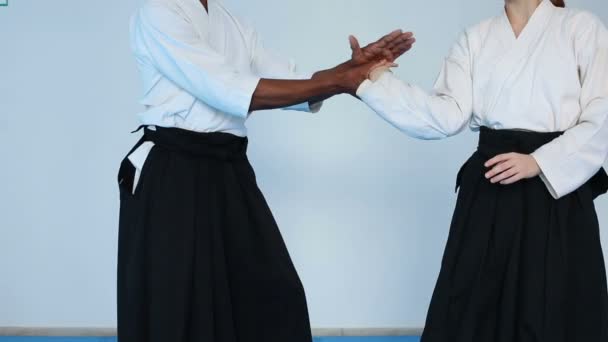 Martial arts meester in de zwarte hakama praktijk Aikido met een vrouw — Stockvideo