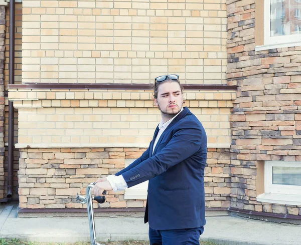 Um belo jovem empresário rolando sua bicicleta — Fotografia de Stock