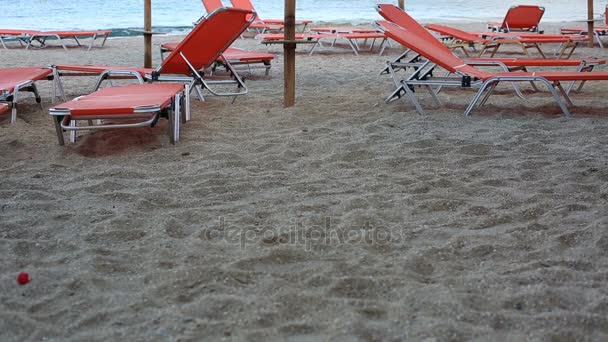 Empty sunbeds standing on a beach by a blue sea — Stock Video