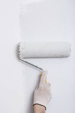 Bir duvar boya silindiri ile boyama ressam kolu yakın çekim