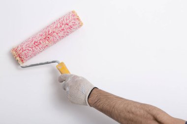 Bir duvar boya silindiri ile boyama ressam kolu yakın çekim