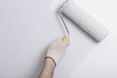 Bir duvar boya silindiri ile boyama ressam kolu yakın çekim