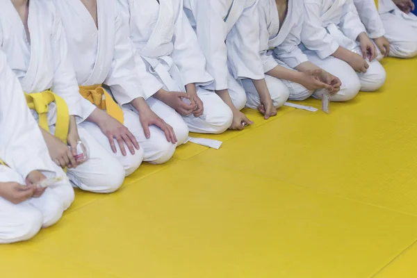 Grupo de crianças em quimono sentado no tatami — Fotografia de Stock