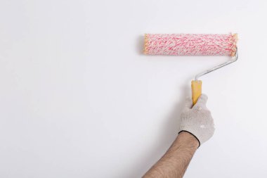 Bir duvar boya silindiri ile boyama ressam kolu yakın çekim