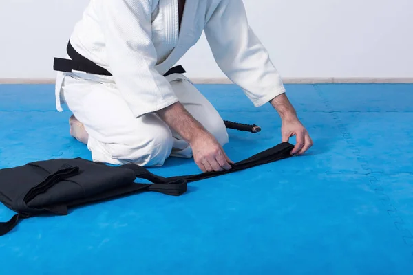 Een martial arts meester met de zwarte gordel zijn hakama vouwen — Stockfoto