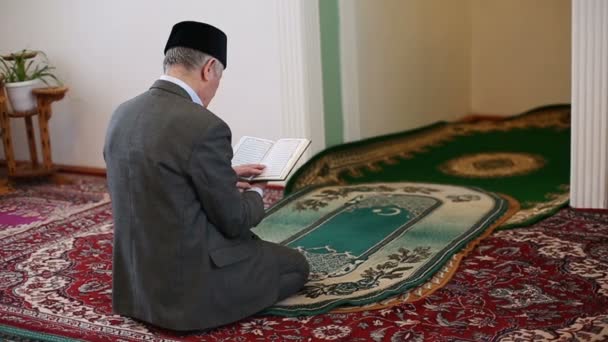 Старый мулла молится с Кораном в руках — стоковое видео