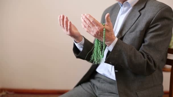 Praying hands of an old man with rosary beads — Stock Video