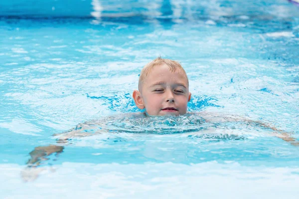Un chico rubio aprendiendo a nadar — Foto de Stock