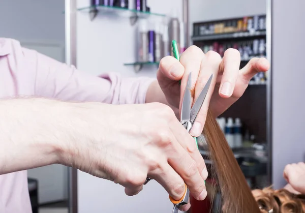 Een kapper die het maken van een kapsel voor een blond meisje — Stockfoto