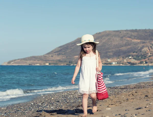 Děvčátko v bílých šatech chodit sám na moře — Stock fotografie