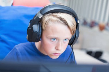 Genç çocuk üstünde Pc ile bilgisayar oyunu oynamak