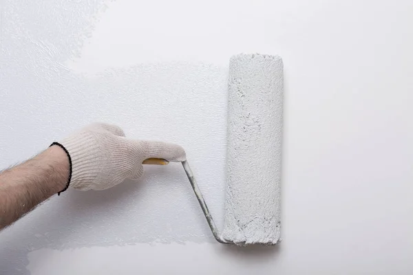 Gros plan du bras du peintre peignant un mur avec rouleau de peinture — Photo