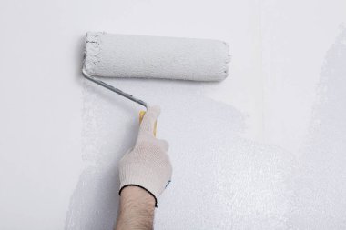 Bir duvar boya silindiri ile boyama ressam kolu yakın çekim