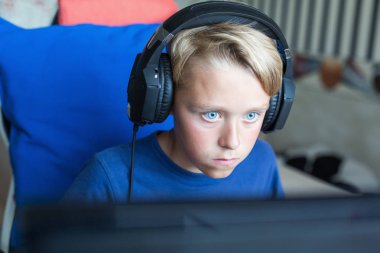 Genç çocuk üstünde Pc ile bilgisayar oyunu oynamak