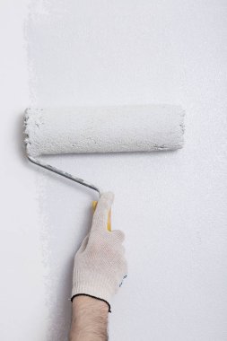 Bir duvar boya silindiri ile boyama ressam kolu yakın çekim