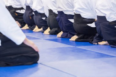 Kimono ve hakama giymiş insanlar dövüş sanatları eğitimi alıyorlar.