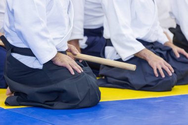 Kimonolu insanlar dövüş sanatları silah eğitimi semineri veriyor.