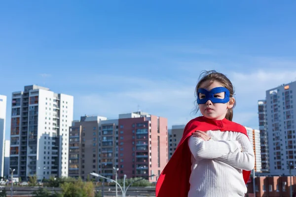 Superhéroe niño contra fondo urbano — Foto de Stock