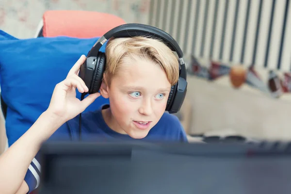 Teenage boy playing computer games on PC