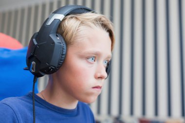 Genç çocuk üstünde Pc ile bilgisayar oyunu oynamak