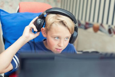 Genç çocuk üstünde Pc ile bilgisayar oyunu oynamak